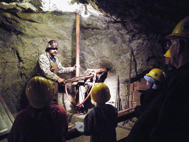 DSCF2886.JPG - Our miner/guide demonstrates one of the old drills.  All tools are powered by compressed air piped from the surface.